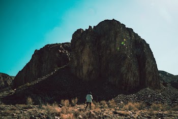 Person Standing in Front of Hill