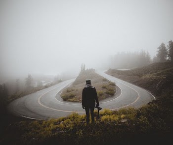 person standing in front of horseshoe-shape road
