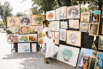 Person Standing in Front of Paintings