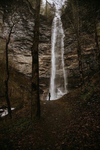 Person Standing In Front Of Waterfalls