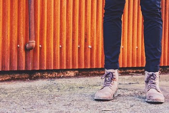 person standing in front orange galvanized iron sheet panel