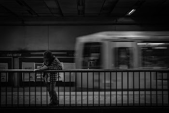 person standing inside train station behind train