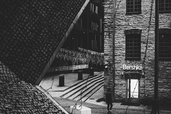 Person Standing Near Bershka Building Grayscale Photography