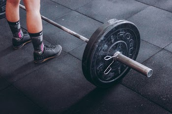Person Standing Near Black Barbell
