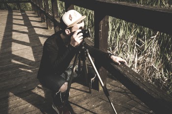 Person Standing Near Camera With Tripod