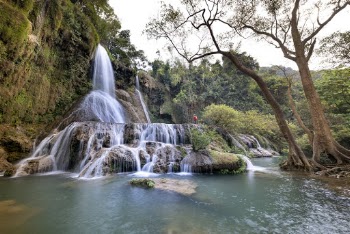 Person Standing Near Waterfalls