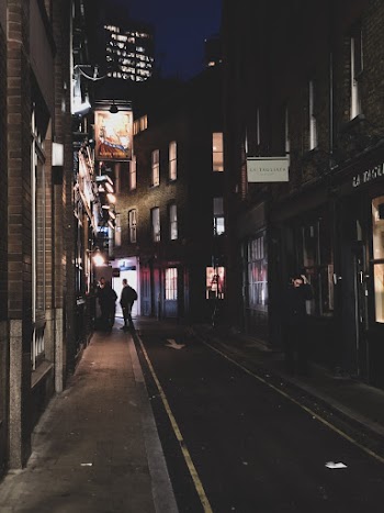 Person Standing on Black Road