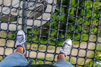 Person Standing on Black Steel Net