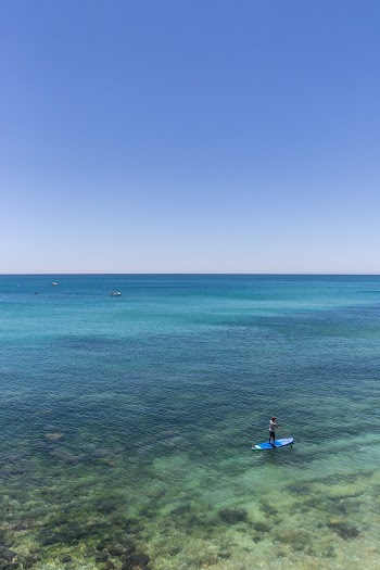 Person Standing On Blue Surfboard