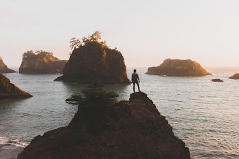 person standing on clear near body of water