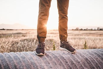 Person Standing on Cylindrical Black Surface