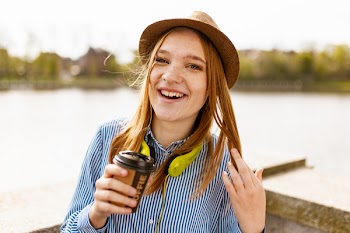 Person Standing on Dock Holding Disposable Cup