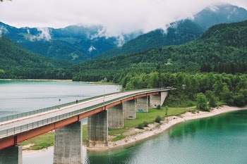 Person Standing on Gray Concrete Bridge
