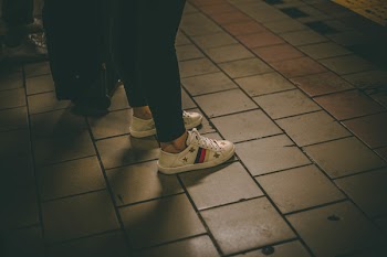 Person Standing on Gray Tiles