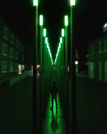 Person Standing On Green Lighted Hallway