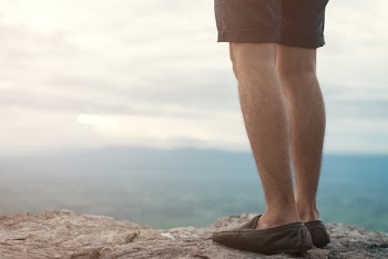 Person Standing on Higher Ground of Mountain