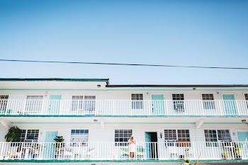 person standing on house terrace leaning on rail