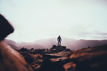 person standing on huge rock