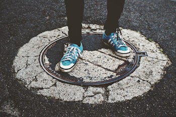 Person Standing on Manhole Cover