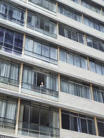 Person Standing on on Building Balcony