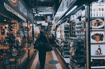 Person Standing on Pathway Near Store