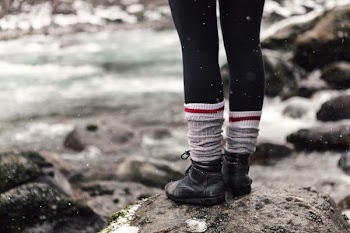 person standing on rock beside river