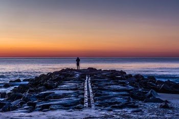 person standing on rocks silhouette