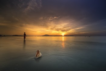 Person Standing on Shallow Water during Golden Hour