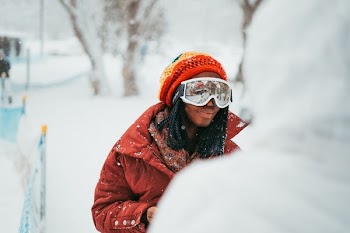 person standing on snow-covered field during daytime