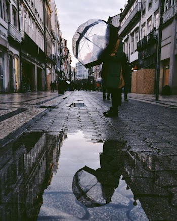 Person Standing on Street Near Puddle
