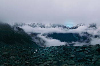 person standing on top of mountain surrounded by sea of clouds