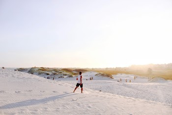 Person Standing on White Sand Open Field