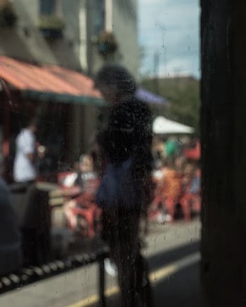 person standing outside glass window