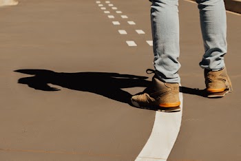 Person Standing Wearing Brown High-top Sneakers on Field
