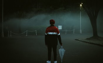 Person Standing While Holding an Umbrella