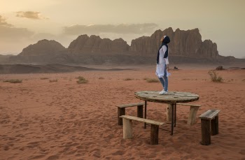 Person Stands on Brown Wooden Table