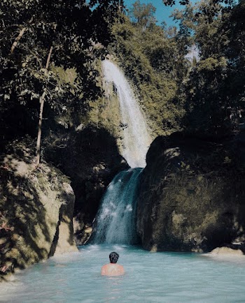 Person Swimming Under Waterfalls