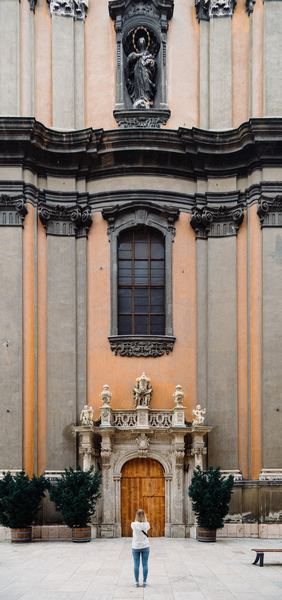 person taking photo of a religious statue