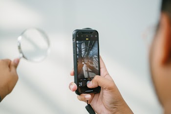 Person Taking Photo Of Magnifying Glass