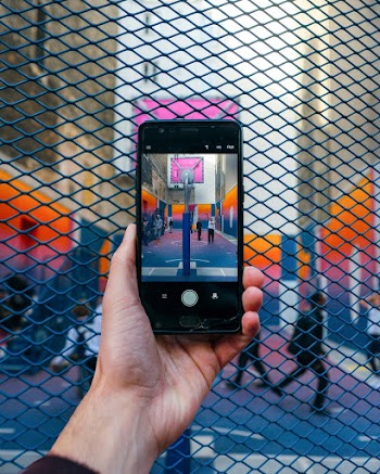 Person Taking Photo Of People In Basketball Court