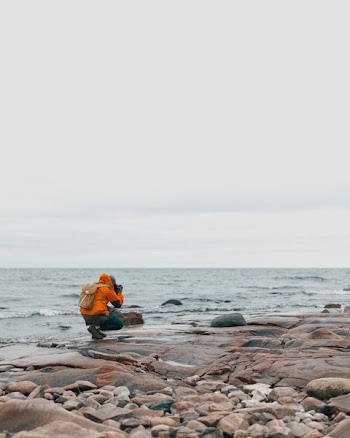 person taking photo of sea waves on beach