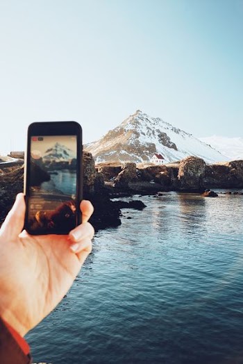 person taking picture on mountain covered with snow