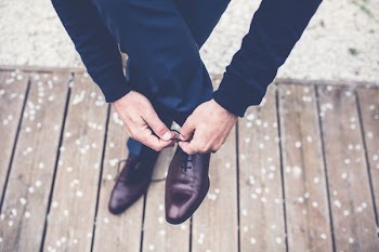 person tied dress shoes