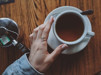 Person Touching a White Coffee Cup With Saucer Close-up Photography