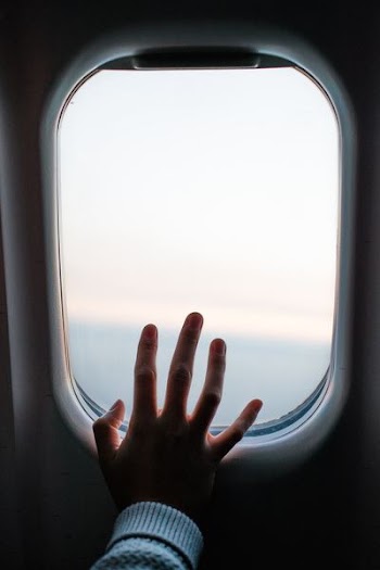 person touching airplane window