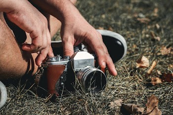 Person Touching Gray and Brown Camera