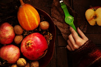 Person Touching Green Analog Watch Between Sliced Apple and Fruit Basket