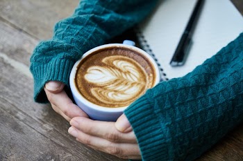 Person Touching Mug With Latte Art