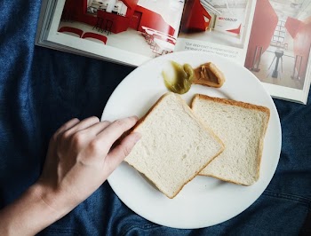 Person Touching the Bread on Plate