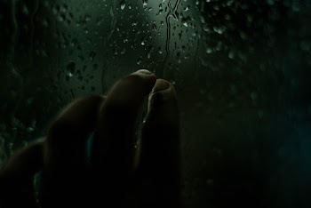 Person Touching Window With Dripping Water